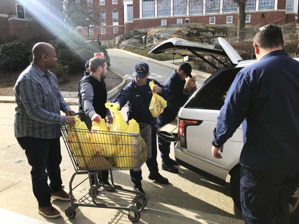 Coast Guard members volunteering at the Coast Guard Academy food pantry accept donations. (Photo: Hayley Miller/HuffPost)