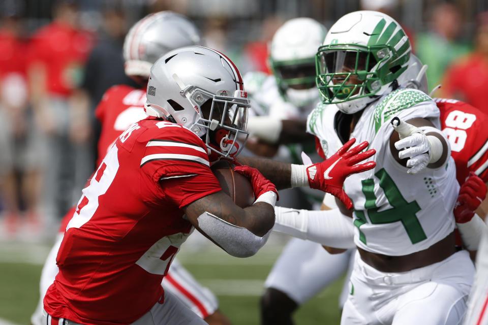 Ohio State running back Miyan Williams, left, tries to run past Oregon defensive lineman Bradyn Swinson during the first half of an NCAA college football game Saturday, Sept. 11, 2021, in Columbus, Ohio. Oregon beat Ohio State 35-28. (AP Photo/Jay LaPrete)