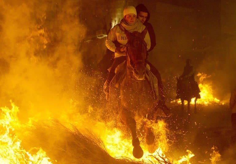 A horsewoman jumps over a bonfire at the Saint Anthony festival in Spain's San Bartolome de Pinares on Wednesday. About 100 Spanish horse riders jumped burning logs, flames leaping into the night, in a controversial, centuries-old rite celebrated every year in the village of San Bartolome de Pinares