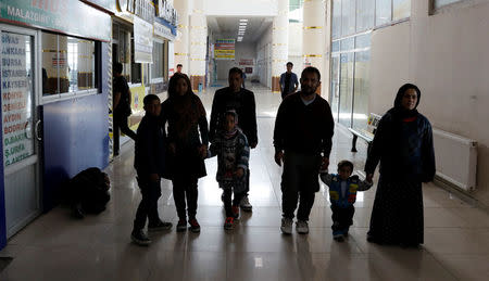 Afghan migrant families walk along the hallway of a bus terminal, as they struggle to find buses to take them to western Turkish cities, after crossing the Turkey-Iran border in Agri, eastern Turkey, April 11, 2018. Picture taken April 11, 2018. REUTERS/Umit Bektas