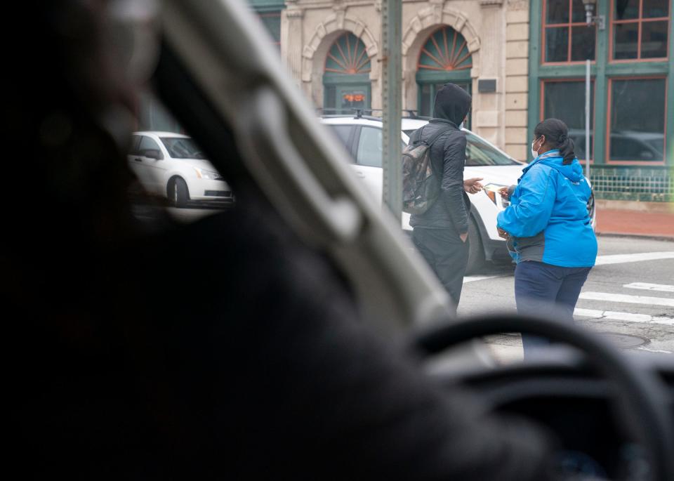 Charquiathia Rogers, 50, of Detroit, left, looks on as outreach manager Stephanie Taylor, 50, right, of Detroit, reaches out to a youth on the streets of Detroit as they ride in the Covenant House Michigan outreach van in hopes of introducing vulnerable and homeless youths to their services on Dec. 9, 2022.