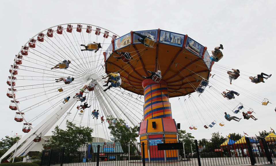 In this Wednesday, June 13, 2012, photo, visitors enjoy the Ferris Wheel and Wave Swinger at Chicago's nearly century-old Navy Pier. Admission is free and Navy Pier is open every day except Thanksgiving and Christmas. It is one of several free activities/things/places visitors can enjoy in Chicago. (AP Photo/Charles Rex Arbogast)