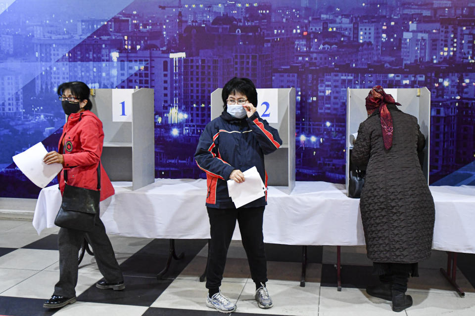 Voters hold their ballots at a polling station during the referendum in Bishkek, Kyrgyzstan, Sunday, April 11, 2021. Voters in Kyrgyzstan cast ballots Sunday on whether to approve a new constitution that would substantially increase the president's powers. The Sunday referendum comes three months after Sadyr Zhaparov was elected president, following the ouster of the previous president amid protests, the third time in 15 years that a leader of the Central Asian country had been driven from office in a popular uprising. (AP Photo/Vladimir Voronin)