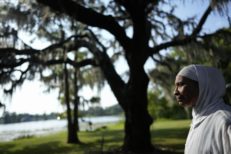 Third-generation town resident NY Nathiri poses for a picture on her family's lakeside property in Eatonville, Fla., Wednesday, Aug. 23, 2023. Nathiri, founder of the Association to Preserve the Eatonville Community, smiles as she reminisces about her idyllic childhood and her family's history in the town, from her grandfather moving there at the beginning of the Great Depression, to her aunts' close relationship with author Zora Neale Hurston. (AP Photo/Rebecca Blackwell)