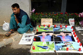 Candles and flowers are laid in front of a building following the murder of a young 27-year-old Afghan man on August 14, shot dead after protesting against urban dirt-bike riding on the sidewalk, in Colmar, northeastern France on August 17, 2022. - 