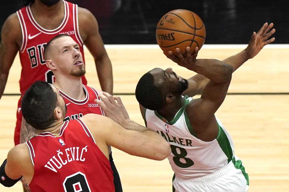 Boston Celtics guard Kemba Walker, right, shoots as Chicago Bulls center Nikola Vucevic and center Daniel Theis watch the ball during the first half of an NBA basketball game in Chicago, Friday, May 7, 2021. (AP Photo/Nam Y. Huh)