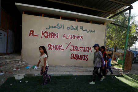 Palestinian children walk at the Bedouin village of Khan al-Ahmar in the occupied West Bank July 12, 2018. REUTERS/Mohamad Torokman