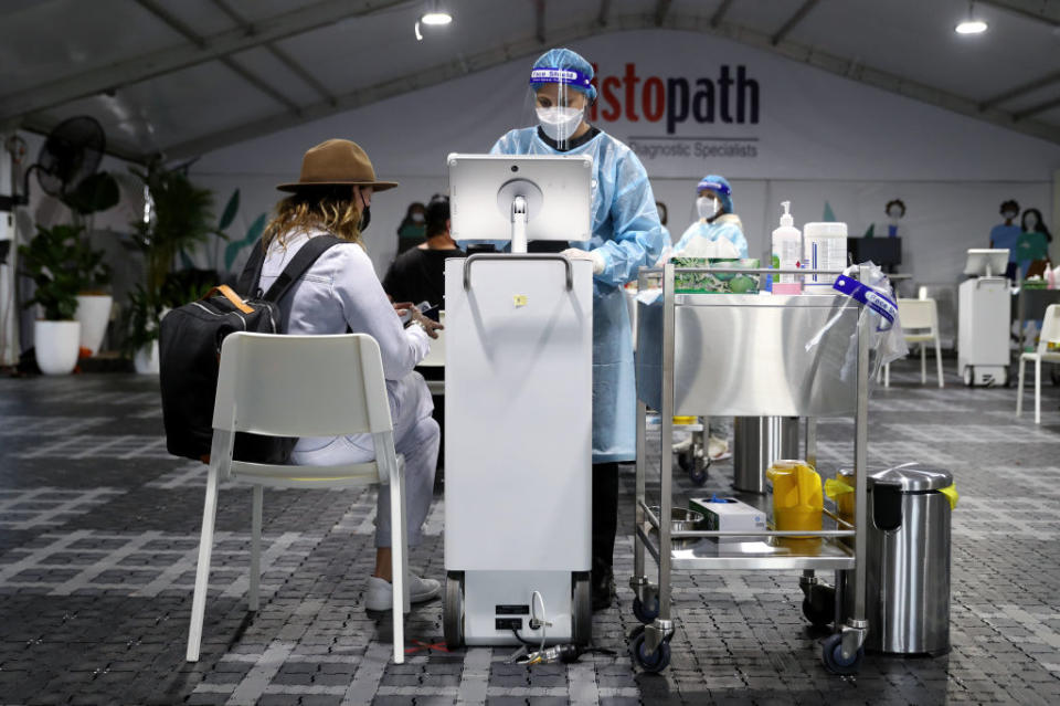 Travelers receive Covid-19 tests ahead of their flights at a Histopath testing clinic at Sydney Airport in Sydney, Australia,