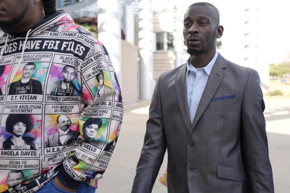 Michael Corey Jenkins, right, follows a friend as he enters the Thad Cochran United States Courthouse in Jackson, Miss., Wednesday, March 20, 2024, for sentencing on the third of the six former Mississippi Rankin County law enforcement officers who committed numerous acts of racially motivated, violent torture on him and his friend Eddie Terrell Parker in 2023. The six former law officers pleaded guilty to a number of federal charges for torturing them and their sentencing began Tuesday in federal court. (AP Photo/Rogelio V. Solis)