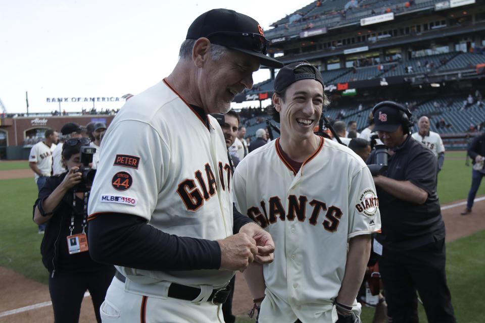 San Francisco Giants manager Bruce Bochy, left, laughs with former player Tim Lincecum during a ceremony honoring Bochy after a baseball game between the Giants and the Los Angeles Dodgers in San Francisco, Sunday, Sept. 29, 2019. (AP Photo/Jeff Chiu, Pool)