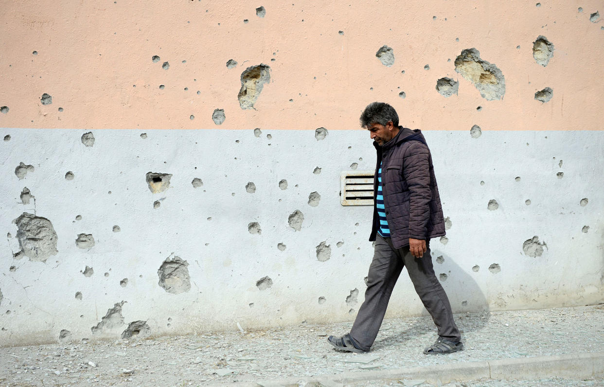 A man walks by a house that was damaged during clashes in the Tartar district bordering the Nagorno-Karabakh region