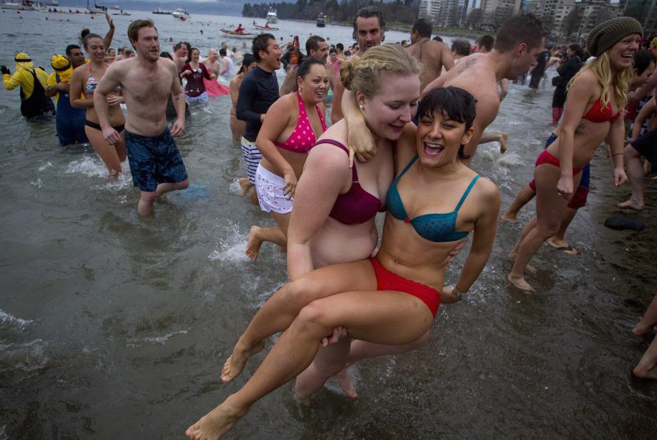 Participants run into English Bay during the 94th annual New Year's Day Polar Bear Swim in Vancouver