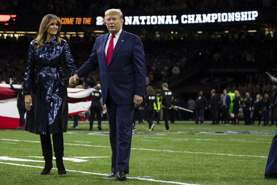 President Donald Trump and first lady Melania Trump walk off the field after the national anthem before the beginning of the College Football Playoff National Championship game between LSU and Clemson, Monday, Jan. 13, 2020, in New Orleans. (AP Photo/ Evan Vucci)