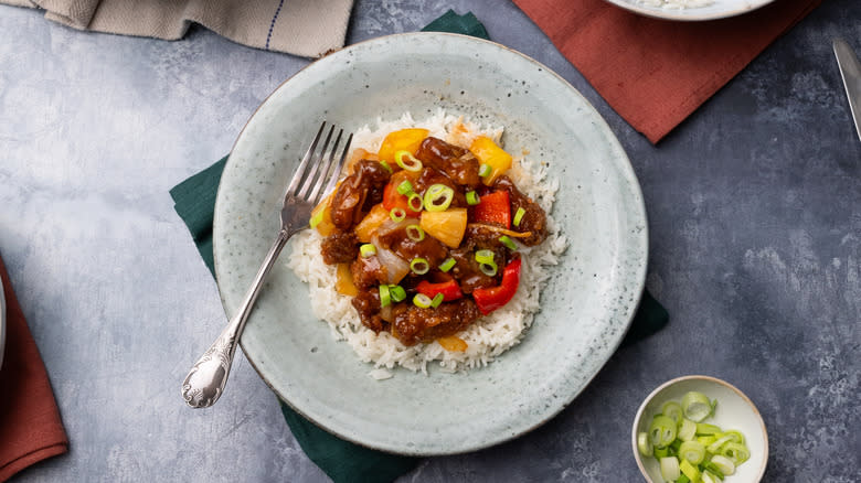 sweet and sour pineapple pork over rice with scallions