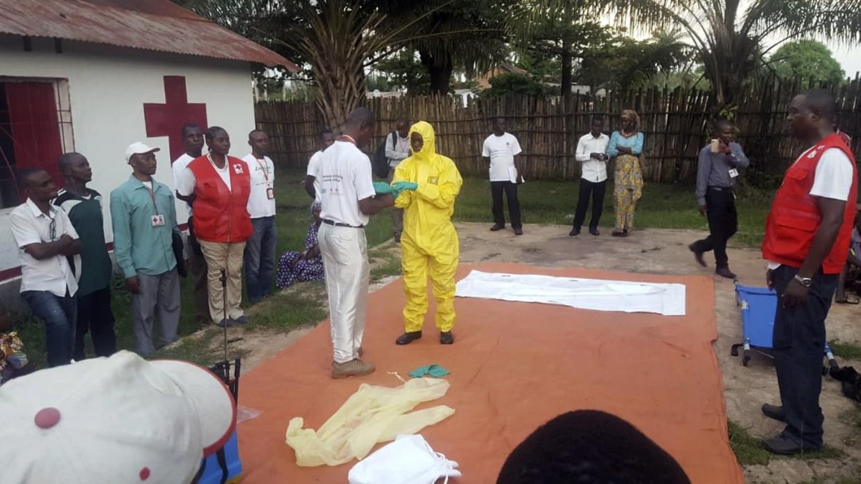 Mitarbeiter vom Roten Kreuz im Kongo ziehen im Vorfeld der Suche nach Infizierten des Ebola-Virus Schutzkleidung an. Foto: Karsten Voigt, IFRC/AP