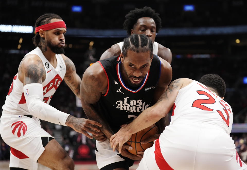 Los Angeles Clippers forward Kawhi Leonard (2) tries to keep the ball from Toronto Raptors guard Gary Trent Jr., forward O.G. Anunoby and guard Fred VanVleet, from left, during the first half of an NBA basketball game Tuesday, Dec. 27, 2022, in Toronto. (Frank Gunn/The Canadian Press via AP)