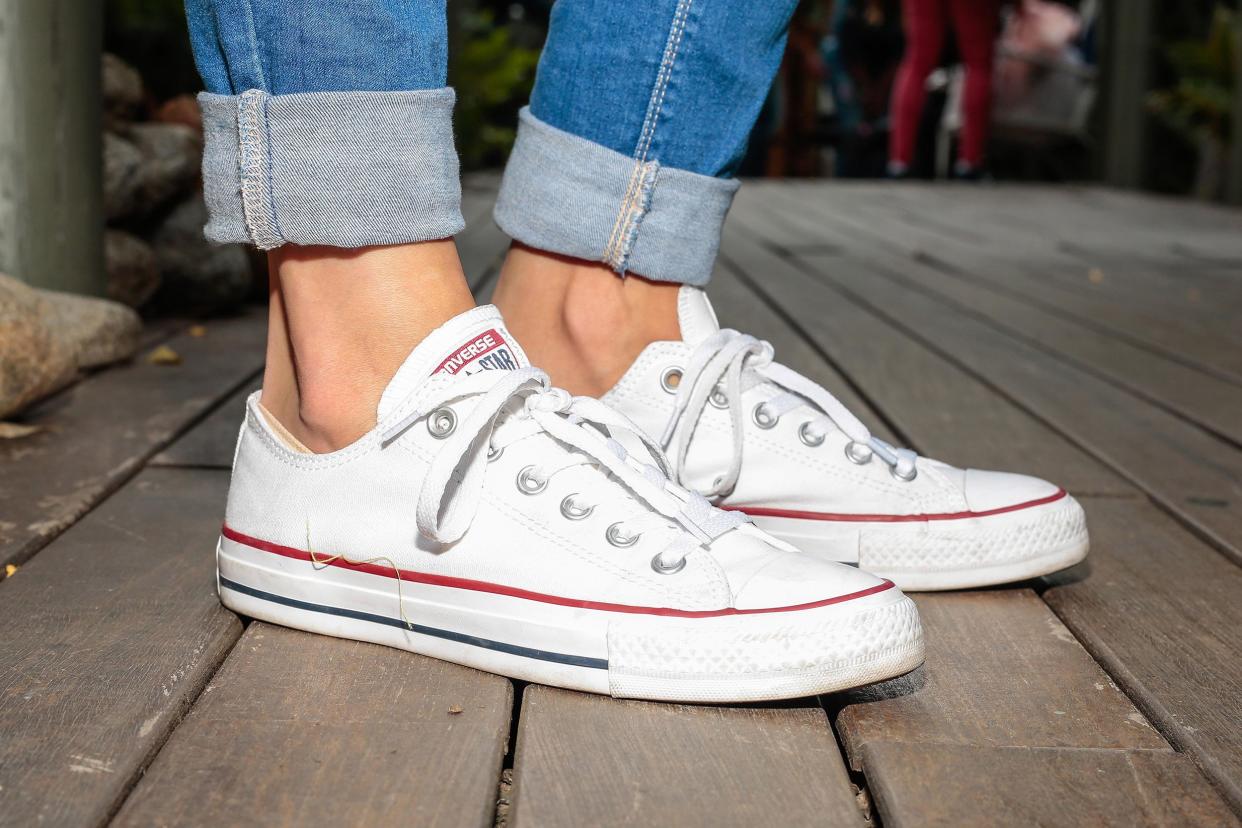 woman wearing Converse All Star white trainers