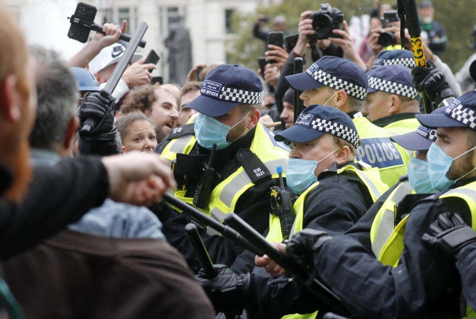 Riot police face protesters who took part in a 'We Do Not Consent' rally at Trafalgar Square, organised by Stop New Normal, to protest against coronavirus restrictions, in London, Saturday, Sept. 26, 2020. (AP Photo/Frank Augstein)