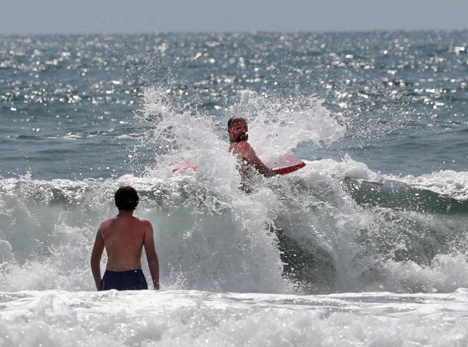 Swimmers play in the waves, Monday, June 27, 2022, near Sun Splash Park.