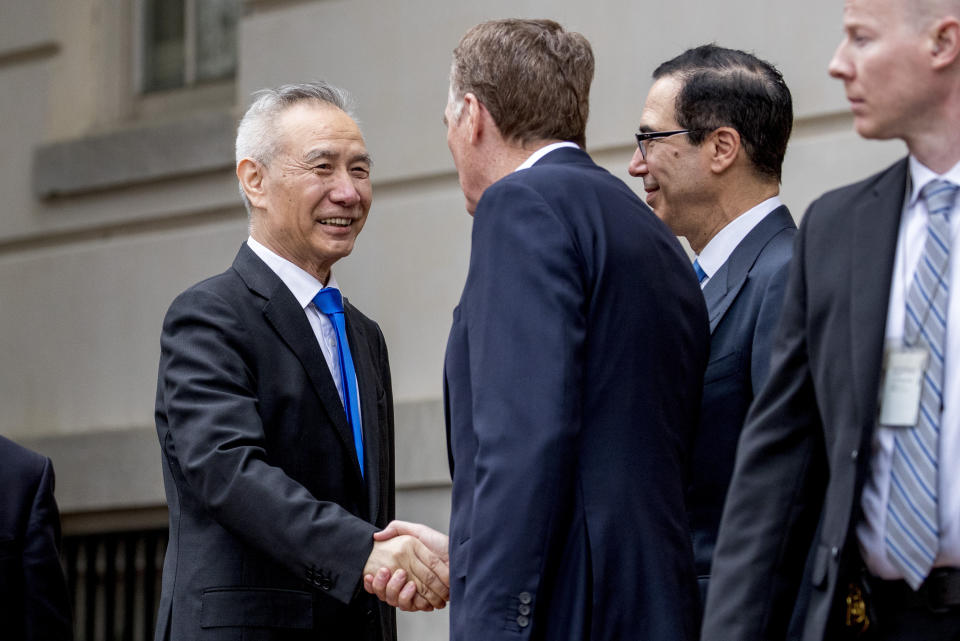 FILE - In this May 10, 2019, file photo, China's Vice Premier Liu He, left is greeted by U.S. Treasury Secretary Steve Mnuchin, second from right, and U.S. Trade Representative Robert Lighthizer, third right, as he arrives at the Office of the United States Trade Representative in Washington. China's Ministry of Commerce said Tuesday that Liu is going to Washington on Thursday for talks aimed at ending the tariff war. (AP Photo/Andrew Harnik, File)