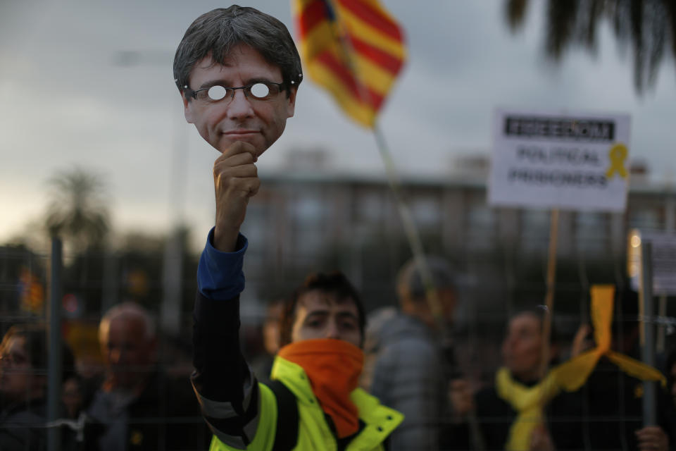 Un manifestante a favor de la independencia de Cataluña sostiene una máscara de Carles Puigdemont, el expresidente de la región, durante una protesta contra su arresto, el domingo 25 de marzo de 2018, en Barcelona. (AP Foto/Manu Fernandez)