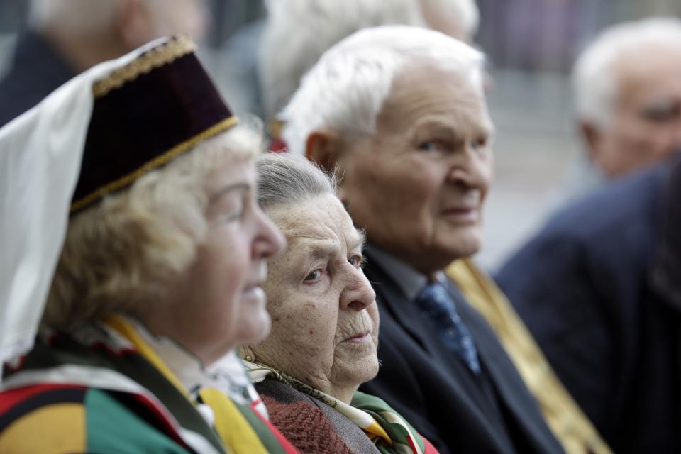 People wait for the arrival of Pope Francis, outside the Museum of Occupations and Freedom Fights, in Vilnius, Lithuania, Saturday, Sept. 22, 2018. Pope Francis is on a four-day visit to the Baltics amid renewed alarm about Moscow's intentions in the region it has twice occupied. (AP Photo/Andrew Medichini)