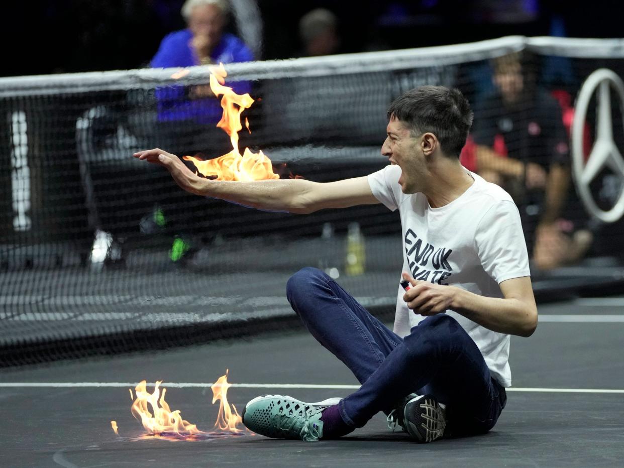 A man sets fire on his hand during protest at a match Team World's Diego Schwartzman against Team Europe's Stefanos Tsitsipas on day one of the Laver Cup tennis tournament at the O2 in London.