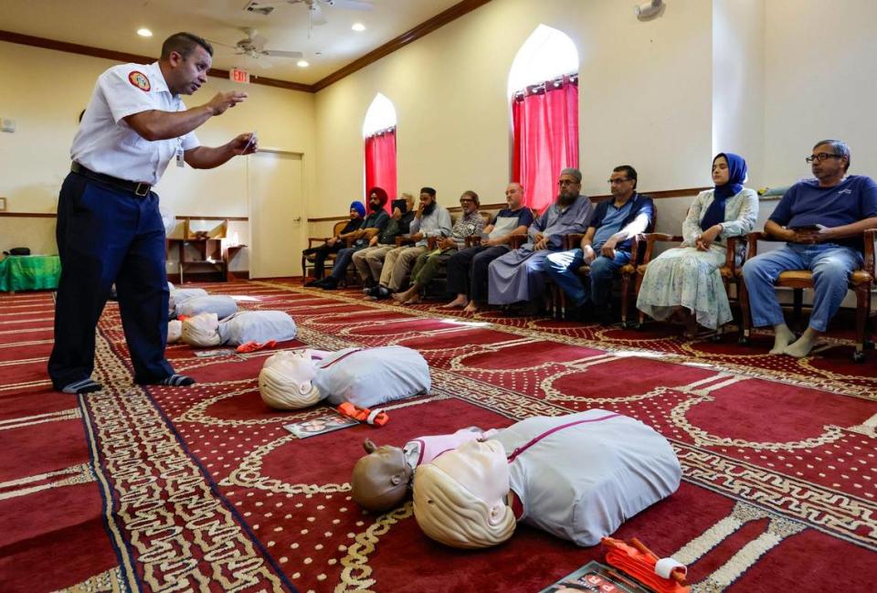 Miami-Dade Fire Rescue Paramedic Lt. Kristian Garcia conducts a training session on how to perform CPR chest compressions or use a tourniquet when responding to a medical emergency as attendees listen at the Islamic Center of Greater Miami-Masjid in Miami Gardens, Florida, Tuesday, June 27, 2023.