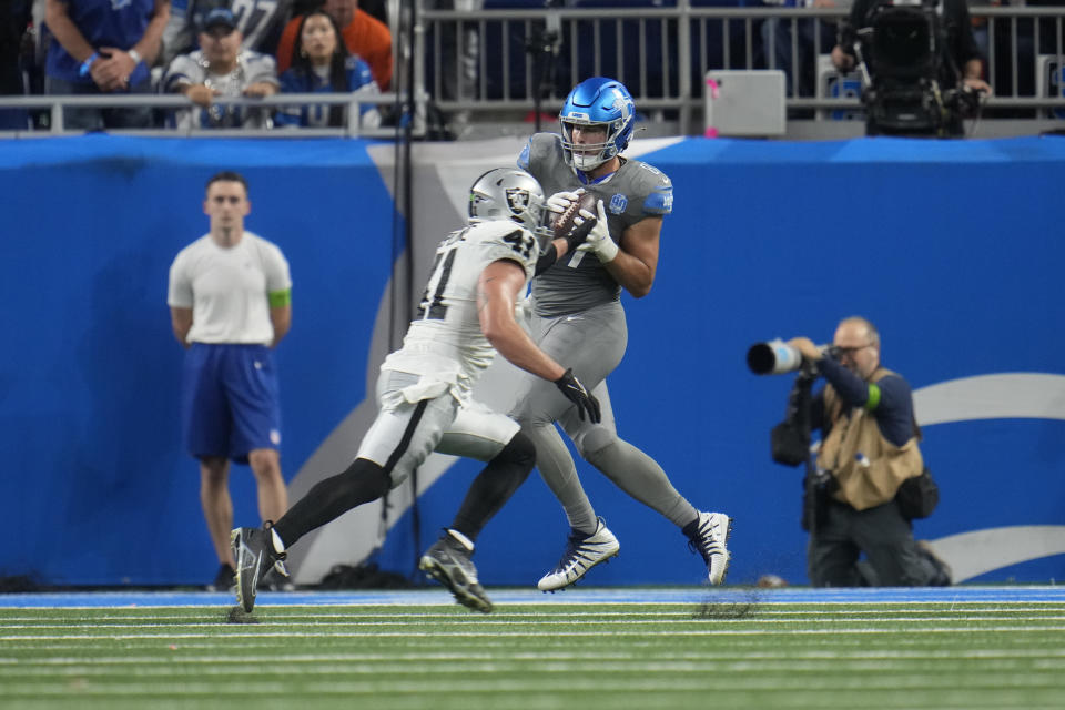 Detroit Lions tight end Sam LaPorta (87), defended by Las Vegas Raiders linebacker Robert Spillane (41), catches a 18-yard pass for a touchdown during the first half of an NFL football game, Monday, Oct. 30, 2023, in Detroit. (AP Photo/Paul Sancya)