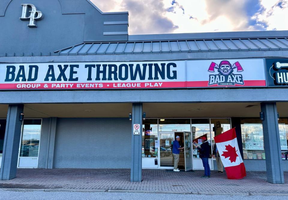 A man carrying an upside-down Canadian flag attempts to enter the axe-throwing venue on Dougall Avenue during a federal Tory event — but is turned away by riding association president Al Teshuba.