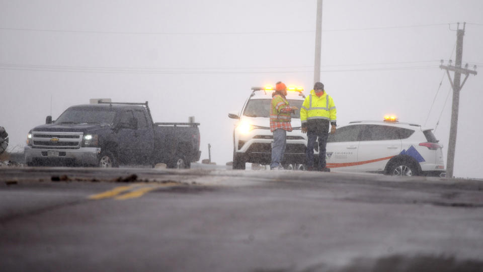 Colorado Department of Transportation workers divert motorists to the westbound lanes of Interstate 70 on the overpass for East Airpark Road, Tuesday, Dec. 13, 2022, in Aurora, Colo. A massive winter storm has closed roads throughout northeast Colorado. (AP Photo/David Zalubowski)