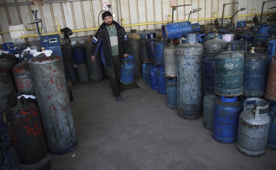 A Palestinian arranges empty cooking gas canisters in Gaza City, Wednesday, March 21, 2012. A test of wills between Egypt and Gaza's Hamas government has produced the worst energy crisis here in years: Gazans are enduring 18-hour-a-day blackouts and the fuel supply is running low. (AP Photo/Adel Hana)