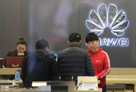 A saleswoman serves customers at a Huawei shop in Beijing, China December 12, 2018. REUTERS/Jason Lee