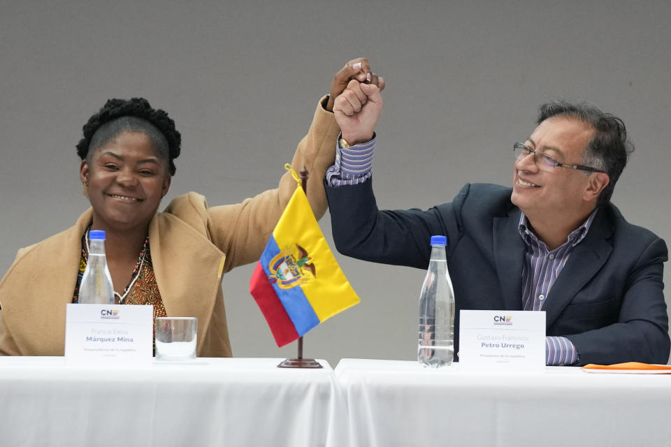 Colombian President-elect Gustavo Petro, right, and running mate Francia Marquez, join hands during a ceremony that certifies their election victory, in Bogota, Colombia, Thursday, June 23, 2022. (AP Photo/Fernando Vergara)