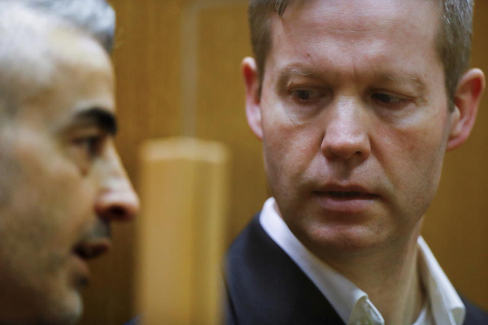 Main defendant Stephan Ernst, right, talks to his his lawyer Mustafa Kaplan, left, in the courtroom at the higher regional court in Frankfurt, Germany, Thursday, Jan. 28, 2021. The German court has convicted the 47-year-old far-right extremist Stephan Ernst of the murder of Walter Luebcke, a regional politician, in a brazen killing that shocked the country, and sentenced to life in prison. (Kai Pfaffenbach/Pool Photo via AP)