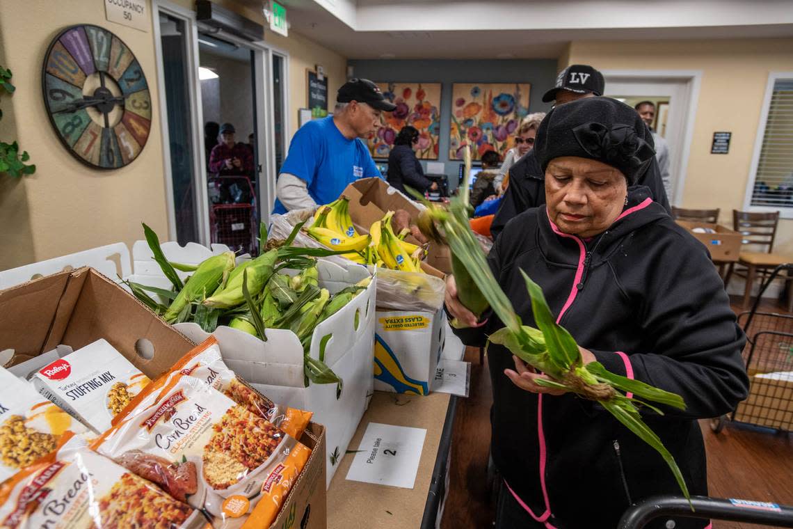 Arbor Creek Family Apartments resident, Mariam Cruz, gathers groceries donated by the Elk Grove Food Bank Services on Nov. 21. The organization asks Book of Dreams readers for donations to resume mobile cooking classes for seniors.