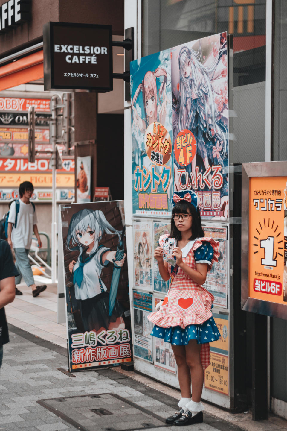 Woman stands out front of a maid cafe