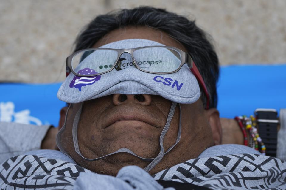 Equipped with a mat, sleeping mask and travel pillow, a man takes a nap at the base of the iconic Monument to the Revolution, during an event dubbed the “mass siesta,” commemorating World Sleep Day, in Mexico City, Friday, March 15, 2024. (AP Photo/Fernando Llano)