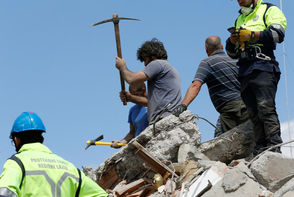 Rescuers work on a collapsed building following an earthquake in Amatrice