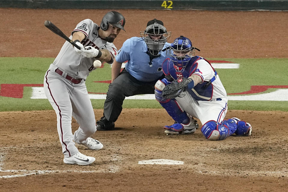 Arizona Diamondbacks' Jace Peterson, left, grounds into a fielder's choice off a pitch from Texas Rangers relief pitcher Martin Perez during the ninth inning in Game 2 of the baseball World Series, Friday, Oct. 27, 2023, in Arlington, Texas. Diamondbacks' Tommy Pham had a chance to become the first player to go 5 for 5 in a World Series game but asked to have Peterson pinch hit for him to ensure his teammate a Series appearance. (AP Photo/Tony Gutierrez)