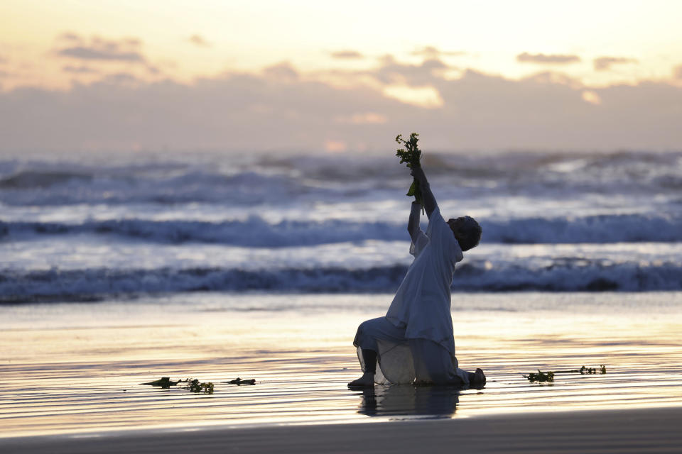 A choreographer performs on the beach in Iwaki, Fukushima prefecture, northern Japan Monday, March 11, 2024 as Japan marked the 13th anniversary of the massive earthquake, tsunami and nuclear disaster. (Kyodo News via AP)