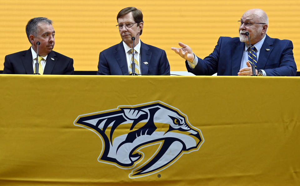 Former Nashville Predators head coach Barry Trotz, right, speaks as general manager David Poile, center, who is retiring in June, listens along with President CEO Sean Henry, left, during a news conference Monday, Feb. 27, 2023, in Nashville, Tenn. Trotz will become the next general manager of the Nashville Predators in July. (AP Photo/Mark Zaleski)