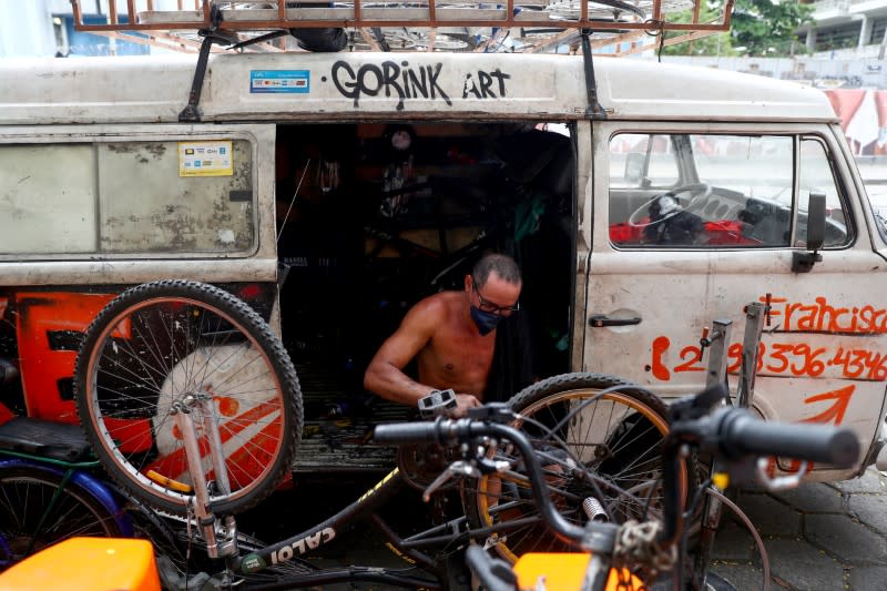 A man wearing a protective mask repairs bicycles, amid coronavirus disease (COVID-19) fears, in Rio de Janeiro