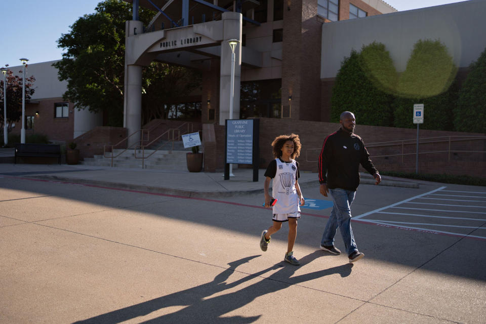 IMage: GCISD School board candidate Sergio Harris leaves Grapevine Library with his son on Saturday. (Danielle Villasana for NBC News)