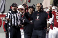 North Carolina State coach Dave Doeren, right, questions an official's call during the first half of the team's NCAA college football game against North Carolina on Friday, Nov. 26, 2021, in Raleigh, N.C. (AP Photo/Chris Seward)