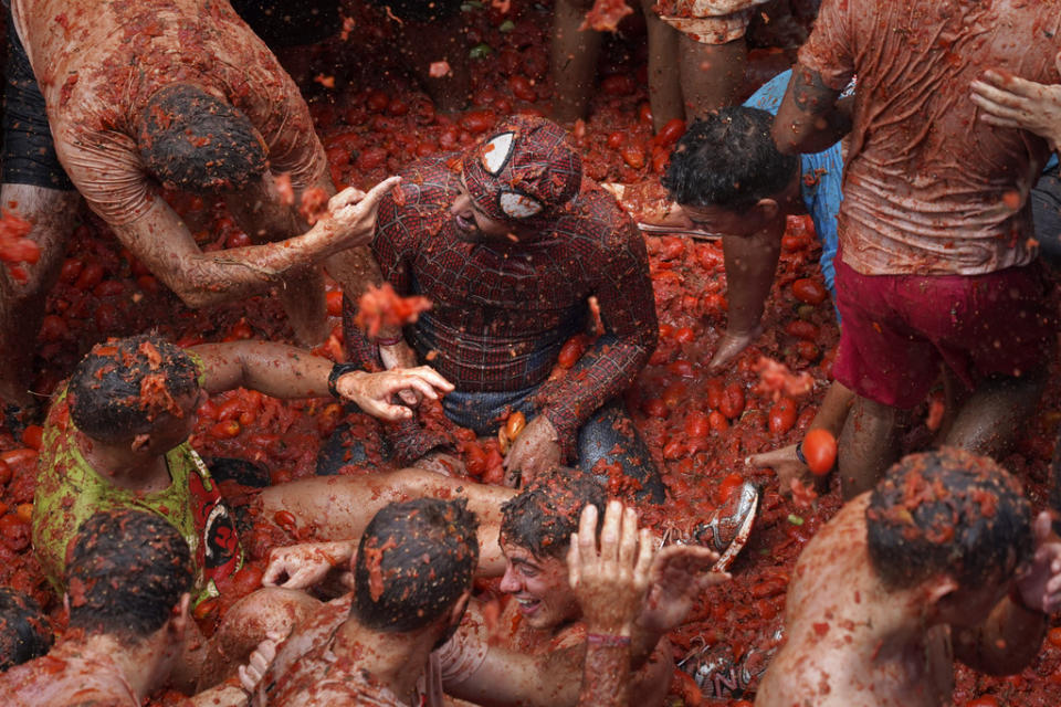 Revellers throw tomatoes at each other during the annual “Tomatina”, tomato fight fiesta, in the village of Bunol near Valencia, Spain, Wednesday, Aug. 30, 2023. Thousands gather in this eastern Spanish town for the annual street tomato battle that leaves the streets and participants drenched in red pulp from 120,000 kilos of tomatoes. (AP Photo/Alberto Saiz)