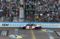 Denny Hamlin (11) takes the checkered flag to win the NASCAR Cup Series auto race Sunday, Nov. 10, 2019, in Avondale, Ariz. (AP Photo/Ralph Freso)