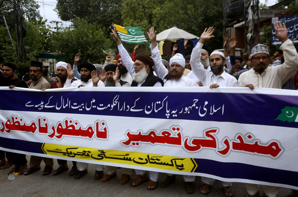 Supporters of the religious group, Sunni Tehreek Pakistan, carry a banner in Urdu that reads, "we disapprove the construction of Hindu temple in the Pakistani capital with government funds", during a demonstration in Lahore, Pakistan, Sunday, July 12, 2020. Analysts and activists say minorities in Pakistan are increasingly vulnerable to Islamic extremists as Prime Minister Imran Khan vacillates between trying to forge a pluralistic nation and his conservative Islamic beliefs. (AP Photo/K.M. Chaudary)