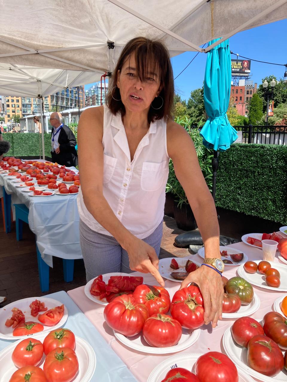 Massachusetts Department of Agricultural Resources volunteer Rose Arruda shows off locally grown tomatoes in August.