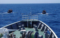 This late May, 2019, photo provided by Japan Coast Guard shows two North Korean fishing boats leaving the waters near Yamatotai, Japan. Coast Guard officials said Tuesday, June 18, they have forced more than 300 North Korean poachers out of Japan’s exclusive economic zone since May near Yamatotai rich with squid. (Japan Coast Guard via AP)